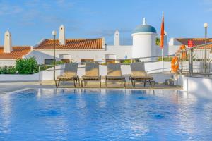 圣米格尔德阿沃纳日落景观俱乐部钻石度假酒店的一组椅子坐在游泳池旁