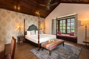 达兰萨拉Brij Anayra Dharamshala - A Himalayan Luxury Retreat的一间卧室配有一张床,卧室配有长凳