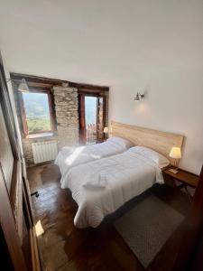 ArmañoCasa Rural Basiver - Habitación Pico Samelar的一间卧室设有两张床和石墙