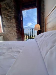 ArmañoCasa Rural Basiver - Habitación Pico Samelar的一间卧室设有一张床和一个美景窗户。
