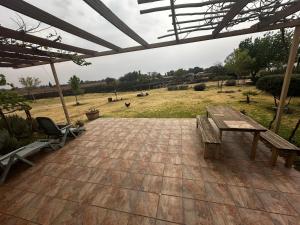 布隆方丹New Joy的庭院设有木桌、长凳和田野。