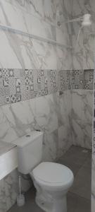 皮雷诺波利斯Hospedagem Central Eu Amo Piri的浴室设有白色卫生间和大理石墙壁。