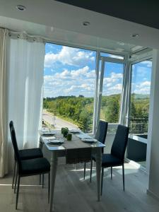 特尔戈维什特Тристаен апартамент Park View的一间带桌椅和大窗户的用餐室