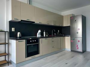 特尔戈维什特Тристаен апартамент Park View的厨房配有白色橱柜和不锈钢冰箱
