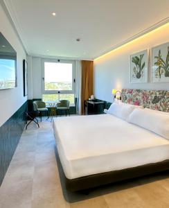 塞维利亚里贝拉特里亚纳酒店的卧室配有一张白色大床