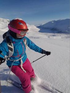 Nord-LenangenIdyllisk hus med sauna og jacuzzi, Lyngen的一个小女孩在雪覆盖的斜坡上滑雪