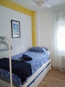 马德里Apartamento luminoso y nuevo en Madrid Rio的一间卧室配有一张床和吊扇