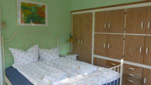 杜塞尔多夫Glück in Benrath的一间卧室配有一张带木橱柜的床。