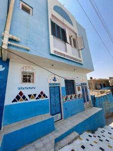 阿斯旺Bakar house的蓝色和白色的建筑,设有蓝色的门