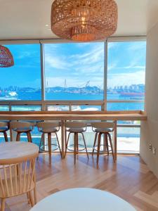 釜山Stay Gaon的一间带桌椅和大窗户的用餐室
