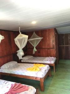 CareiroIpanema Lodge的客房设有2张床,天花板上设有蚊帐。