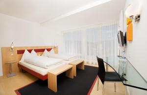 施皮茨Hotel Seaside的卧室配有1张床、1张桌子和1把椅子