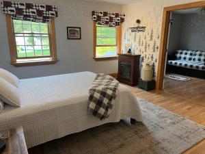 ConneautThe Inn at Woodsong Acres的一间卧室设有一张床和一间客厅。
