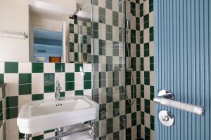 巴黎Hôtel La Conversation的浴室设有水槽和绿色及白色瓷砖