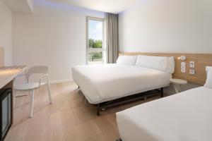 莱里达B&B HOTEL Lleida的酒店客房配有一张床铺和一张桌子。