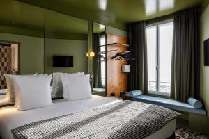 巴黎Hôtel La Conversation的一间卧室设有一张大床和一个窗户。