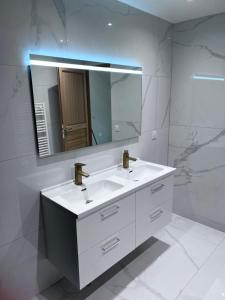 圣热讷维耶夫代布瓦VILLA LENA的浴室设有白色水槽和镜子