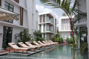 阿比让La Maison Palmier Abidjan, a Member of Design Hotels的游泳池旁的一排躺椅