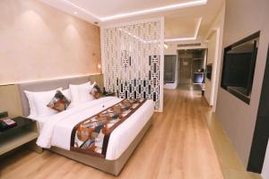 阿姆利则Regenta Place Amritsar by Royal Orchid Hotels Limited的卧室配有一张白色大床和电视。