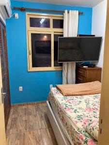 彼得罗波利斯Apartamento aconchegante no Hotel Quitandinha com vaga de garagem的一间卧室配有一张床和一台平面电视