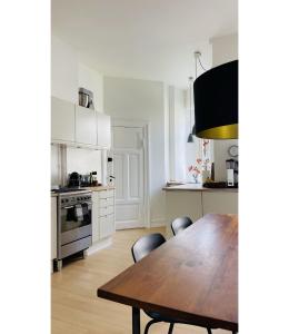 哥本哈根ApartmentInCopenhagen Apartment 1563的厨房配有木桌和椅子