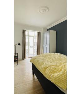 哥本哈根ApartmentInCopenhagen Apartment 1563的一间卧室配有一张黄色毯子床