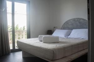 圣费兰-德瑟斯罗Hostal Bon Sol的一间卧室设有一张大床和大窗户