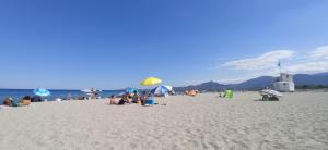 滨海阿热莱斯HappyMobilhome Argelès-sur-mer -plage à 500m- Camping 4 étoiles Del Mar的一群人在海滩上,带遮阳伞