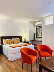 乌拉圭河畔康塞普西翁Gran Texier Hotel Casino的一间卧室配有一张床、两把椅子和一张桌子