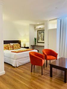 乌拉圭河畔康塞普西翁Gran Texier Hotel Casino的一间卧室配有一张床、两把椅子和一张桌子