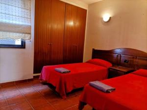 圣地亚哥海滩Casa Marina-Hardling的一间卧室配有两张红色床单