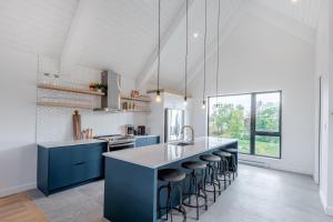 博普雷SOFA VILLAS MONT SAINTE-ANNE的厨房配有蓝色橱柜和带凳子的台面