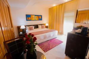 突尼斯顶楼套房酒店公寓的配有一张床和花瓶的酒店客房