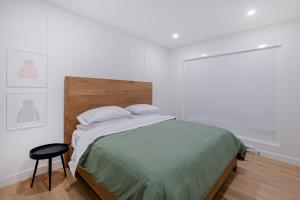 博普雷SOFA VILLAS MONT SAINTE-ANNE的白色卧室配有床和凳子