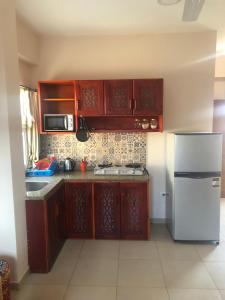 达哈布Dahab Relax Studio 3的厨房配有木制橱柜和白色冰箱。