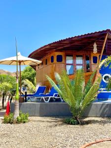 索里托斯索里托斯海滩酒店的一座配有蓝色躺椅和遮阳伞的房子