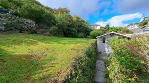 波特洛Bay Cottage的一座建筑物旁边的草地上的小棚子