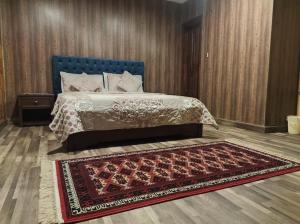 穆里Holiday home On The rocks的一间卧室配有一张带蓝色床头板和地毯的床。