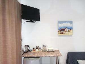 科尔斯伯格7 On Grey Guesthouse的一间房间,墙上设有一张桌子和一台电视