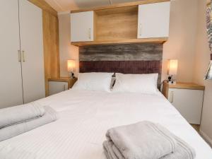 斯基普顿31 Willows的卧室配有白色的床和2条毛巾