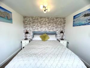 多切斯特Tumbleweed 2的一间卧室配有白色床和2个床头柜
