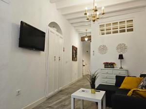 麦地那西多尼亚Apartamento Casa Pura的客厅配有沙发和墙上的电视