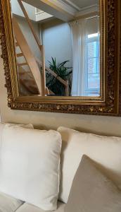 那慕尔Le 25, Duplex élégant au cœur du piétonnier historique的沙发上方的镜子,配有白色枕头
