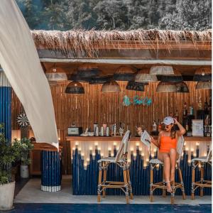 库德岛库德岛休闲海度假村的坐在酒吧椅子上的女人