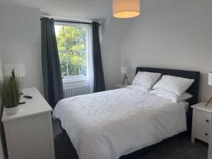 温彻斯特Riverside 3 Bed House的卧室配有白色的床和窗户。