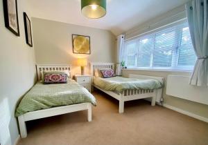 杜伦Spacious, Durham City Retreat的一间卧室设有两张床和窗户。