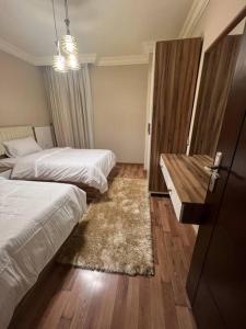 Sheikh Zayedدوبلكس بيفرلي هيلز اربع غرف الشيخ زايد فرش مودرن的酒店客房设有两张床和一张桌子。