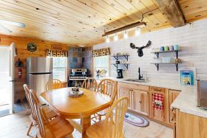 The Mink Brook Retreat的厨房设有木桌和木制天花板。