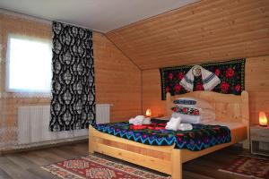 BrebCasa Vladicu的木制客房内的一间卧室,配有一张床