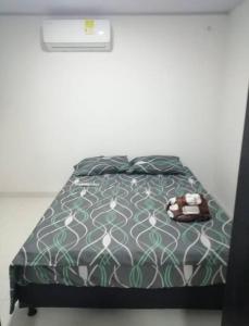 CoveñitasHermoso apartamento en Coveñas con piscina的一张带绿色和白色棉被的床